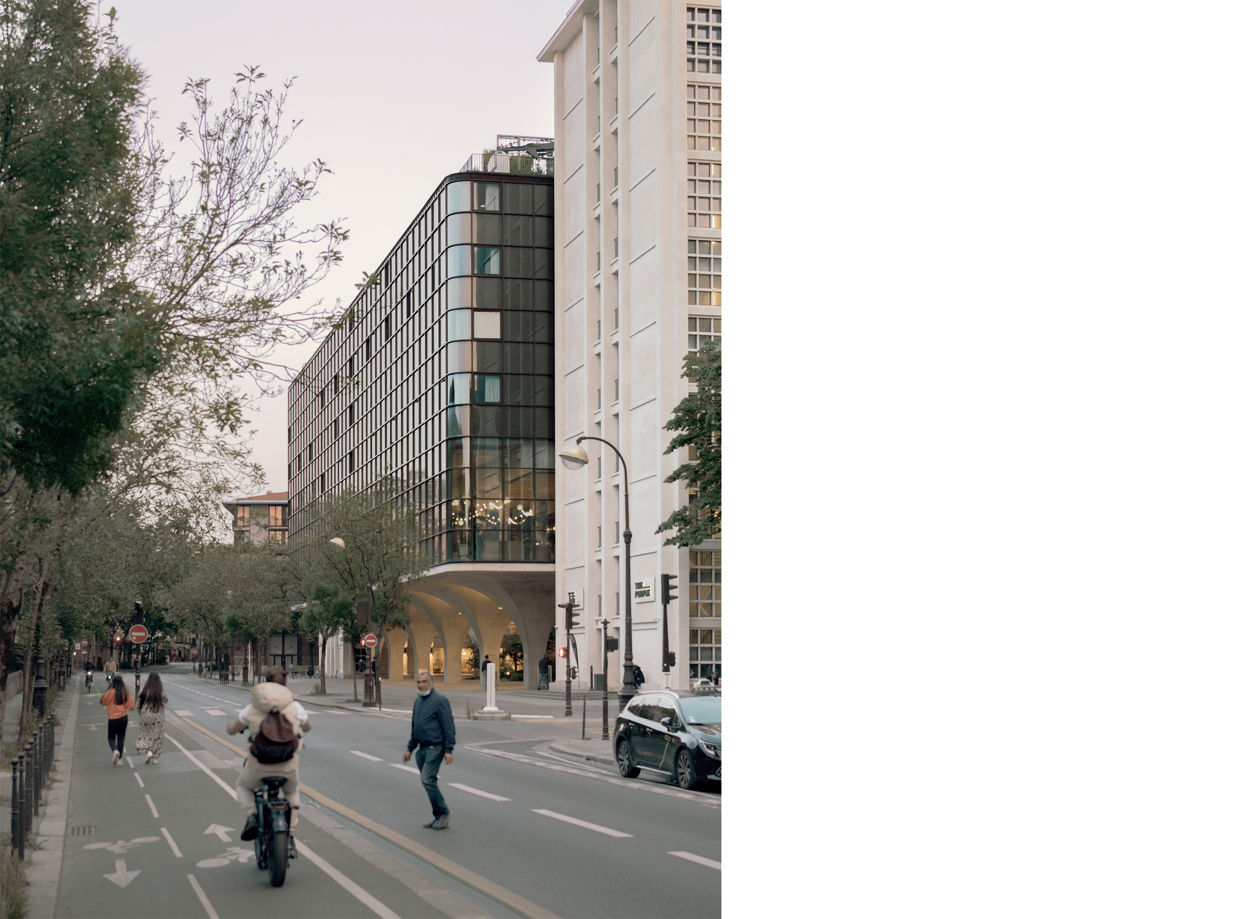 Street-level view of Morland Mixité Capitale showing the restored and extended building along Boulevard Morland, with arcades, cyclists and pedestrians activating the public realm.