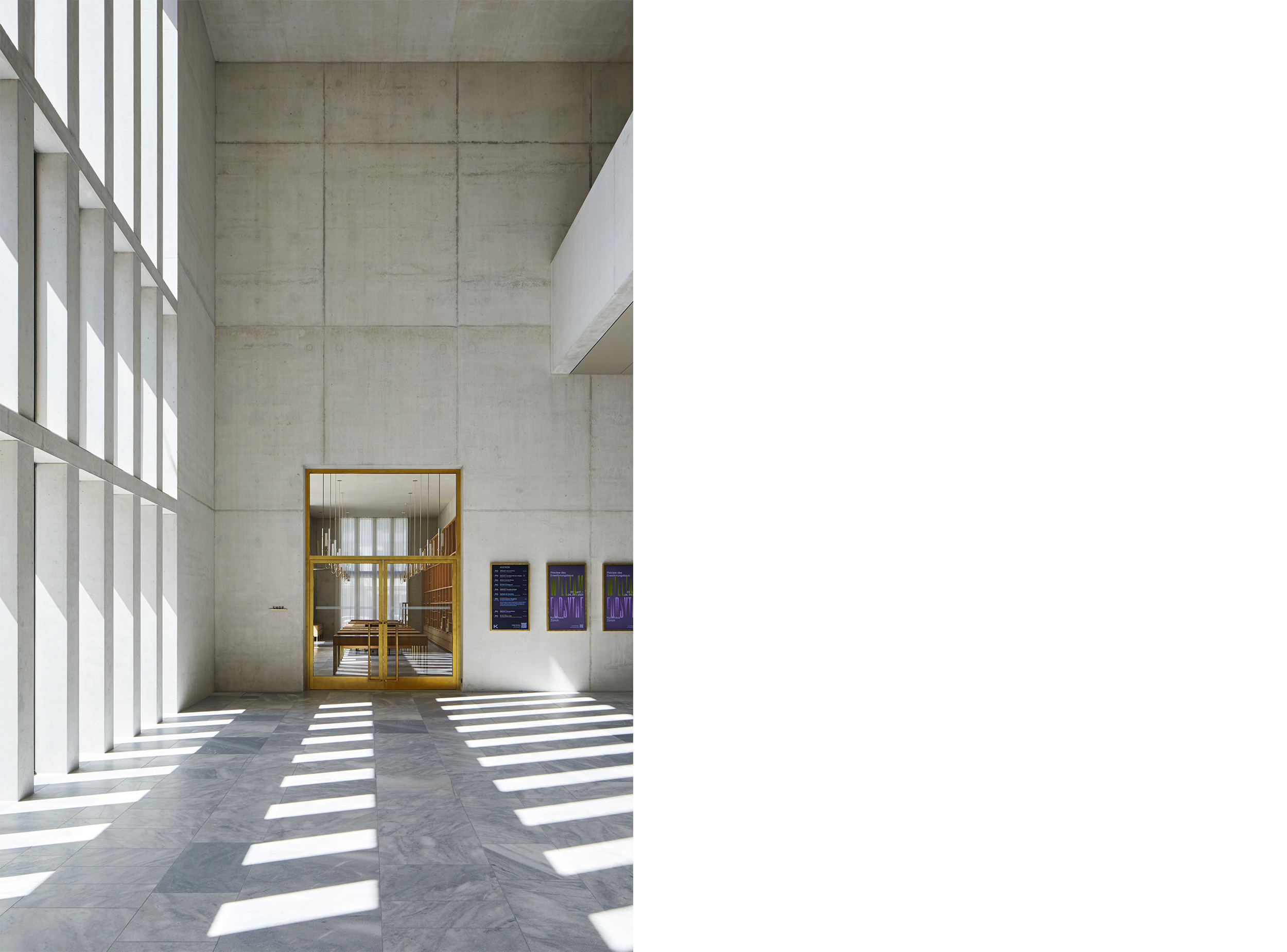 Natural light filters through tall vertical openings in the central hall of the Kunsthaus Zürich Extension, animating the marble floor and revealing the restrained material palette of concrete, stone and brass that characterises the museum’s public spaces.