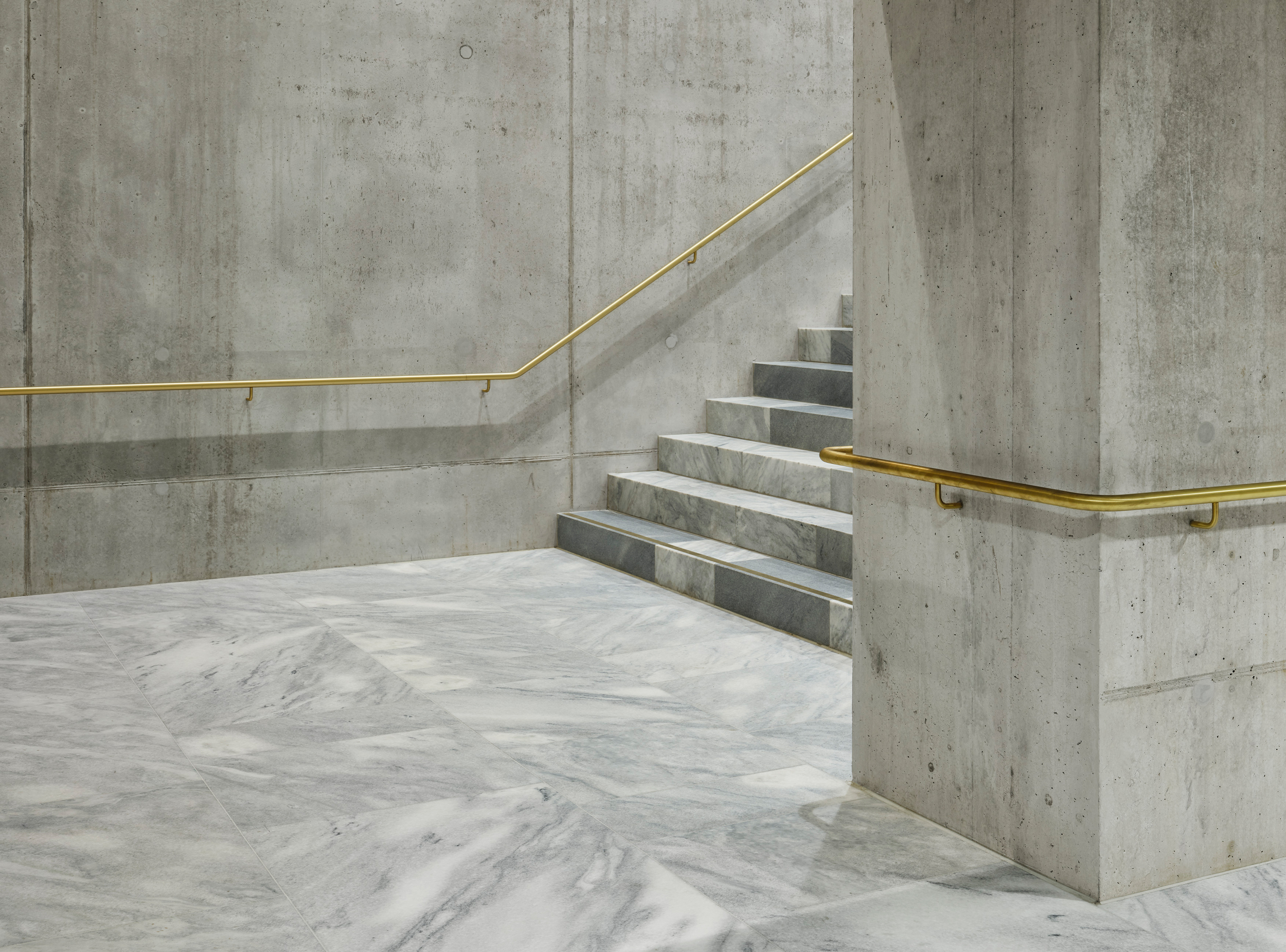 A carefully composed junction of marble floor, stair and exposed concrete structure within the Kunsthaus Zürich Extension, demonstrating the project’s emphasis on material precision, craftsmanship and spatial clarity.